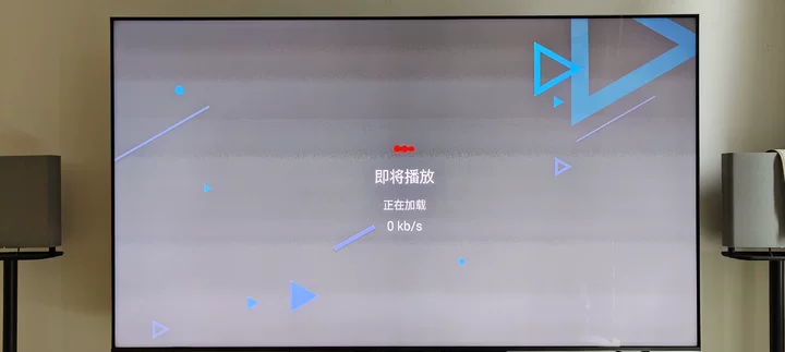 电视屏幕显示视频缓冲界面，中央显示文字即将播放、正在加载及0 kb/s